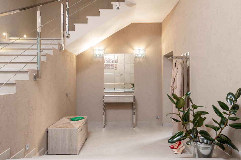 Contemporary hallway with beige walls, staircase and warm ambient lighting